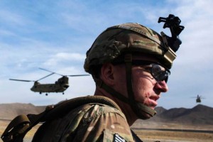 A U.S. soldier from the 3rd Cavalry Regiment waits for a CH-47 Chinook helicopter from the 82nd Combat Aviation Brigade to land after an advising mission at the Afghan National Army headquarters for the 203rd Corps in the Paktia province of Afghanistan December 21, 2014. REUTERS/Lucas Jackson (AFGHANISTAN - Tags: CIVIL UNREST POLITICS MILITARY)