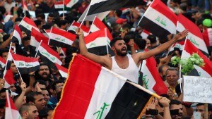 Iraqi demonstrators wave national flags during a demonstration to express support for Prime Minister Haider al-Abadi's reform drive while calling on him to do more on August 14, 2015 in Baghdad's Tahrir Square. Abadi announced on August 9, 2015 a reform programme in response to weeks of protests and to a call for drastic change from Iraq's top Shiite cleric, Grand Ayatollah Ali al-Sistani. Parliament approved the plan, along with additional measures, two days later.    AFP PHOTO / HAIDAR MOHAMMED ALI        (Photo credit should read HAIDAR MOHAMMED ALI/AFP/Getty Images)