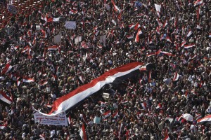 People carry an Egyptian flag as they arrive to attend Friday prayers and a demonstration in Tahrir Square in Cairo, Egypt, Friday Feb. 18, 2011. Protests continued and labor unrest has increased in Egypt since President Hosni Mubarak's departure last week that set off a chain reaction around the Middle East, with anti-government demonstrations reported in Libya, Bahrain and Yemen.(AP Photo/Hussein Malla)