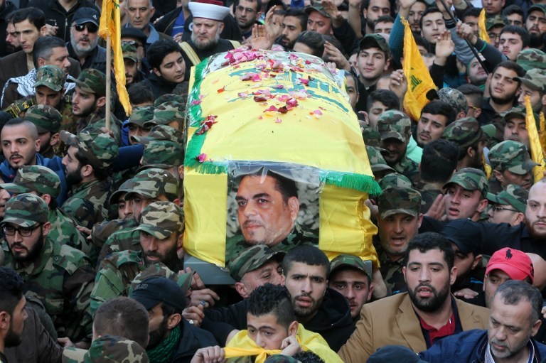 Members of Lebanon's militant Shiite Muslim movement Hezbollah carry the coffin of Lebanese militant Samir Kantar (portrait), who was killed in a suspected Israeli air-raid on his home in the Jaramana district on the outskirts of the Syrian capital Damascus, during his funeral procession in a southern suburb of the Lebanese capital Beirut on December 21, 2015. Israel's justice minister welcomed the death of Kantar but did not claim credit for the air strike in Syria that killed him, which Hezbollah said was an Israeli raid. AFP PHOTO / STR / AFP / -