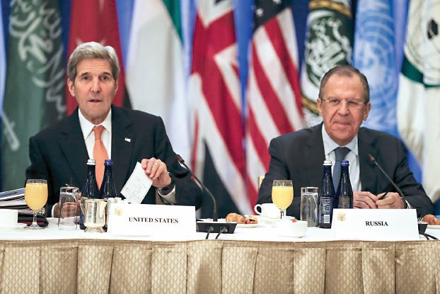 U.S. Secretary of State John Kerry (L) and Foreign Minister of Russia Sergey Lavrov are seen seated next to each other before a meeting of Foreign Ministers about the situation in Syria at the Palace Hotel in the Manhattan borough of New York December 18, 2015.     REUTERS/Carlo Allegri