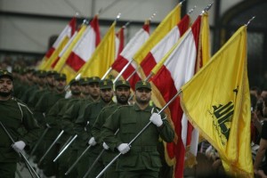 Hezbollah fighters, holding up national flags and the yellow flag of the militant Shiite Muslim group, parade on the occasion of Martyr's Day in the southern suburbs of Beirut November 11, 2009. Lebanon's incoming Prime Minister Saad Hariri announced earlier this week the new cabinet line-up after nearly five months of tough negotiations with his rivals in the Iran- and Syria-backed Hezbollah-led alliance. AFP PHOTO/RAMZI HAIDAR (Photo credit should read RAMZI HAIDAR/AFP/Getty Images)