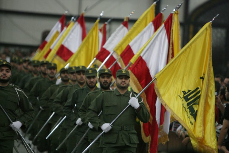 Hezbollah fighters, holding up national flags and the yellow flag of the militant Shiite Muslim group, parade on the occasion of Martyr's Day in the southern suburbs of Beirut November 11, 2009. Lebanon's incoming Prime Minister Saad Hariri announced earlier this week the new cabinet line-up after nearly five months of tough negotiations with his rivals in the Iran- and Syria-backed Hezbollah-led alliance.  AFP PHOTO/RAMZI HAIDAR