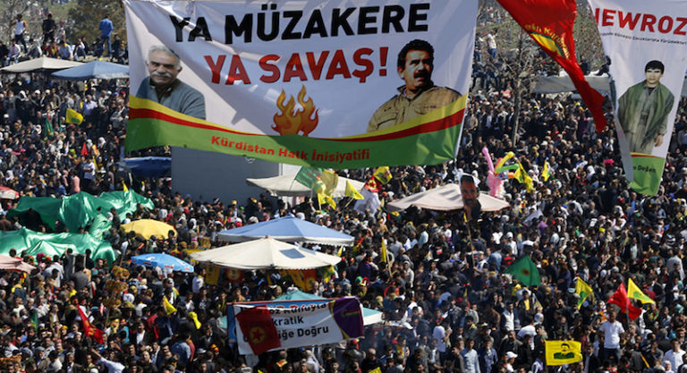 A giant banner, which reads: "Negotiation or war" and shows different pictures of jailed Kurdish militant leader Abdullah Ocalan of the Kurdistan Workers Party (PKK), is displayed during a gathering celebrating Newroz, which marks the arrival of spring and the new year, in Diyarbakir March 21, 2014. Ocalan called on the Turkish government on Friday to create a legal framework for their peace talks, whose fate is looking increasingly uncertain a year after he called a ceasefire by his fighters. Tens of thousands gathered in Diyarbakir, the largest city in Turkey's mainly Kurdish southeast, for the Kurdish new year celebrations of Newroz, where they listened to a statement written by Ocalan in his island jail of Imrali near Istanbul. REUTERS/Umit Bektas (TURKEY - Tags: POLITICS SOCIETY ANNIVERSARY) - RTR3I2BN